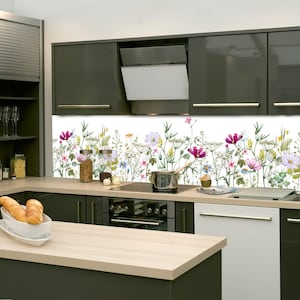Könnte beinhalten: Eine moderne Küche mit grauen Schränken und einer weißen Spritzschutzwand mit einem Blumendesign. Die Spritzschutzwand zeigt eine Vielzahl von rosa, weißen und gelben Blumen mit grünen Blättern.