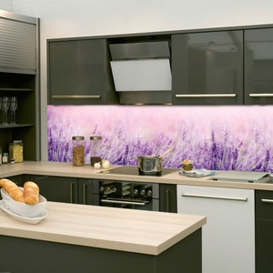 Può includere: Una cucina moderna con armadi grigi e un paraschizzi a tema lavanda. Il paraschizzi presenta un primo piano di un campo di fiori di lavanda su uno sfondo rosa tenue.