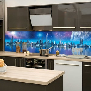 Puede incluir: Una cocina moderna con armarios de color marrón oscuro y un protector contra salpicaduras de vidrio que presenta una ciudad futurista reflejada en el agua. El protector contra salpicaduras tiene un esquema de color azul, morado y blanco con una luna grande y brillante en el cielo.