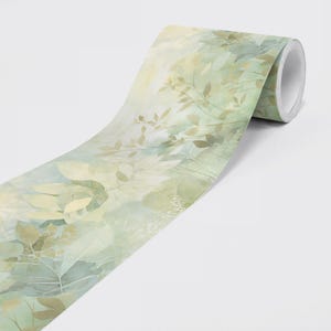 May include: A roll of decorative washi tape featuring a watercolor design of leaves and branches in shades of green, beige, and yellow. The tape has a soft, artistic aesthetic.