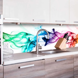 Könnte beinhalten: Eine Küchenrückwand mit einem farbenfrohen abstrakten Design aus wirbelndem Rauch in Grün-, Blau-, Lila-, Rot- und Gelbtönen. Die Rückwand ist über einer weißen Arbeitsplatte mit einem Spülbecken und einem Wasserhahn aus Edelstahl installiert.