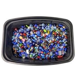 May include: A black plastic container filled with a variety of colorful beads. The beads are primarily blue, with accents of red, green, yellow, and white. The beads are of various shapes and sizes, including round, cylindrical, and irregular.