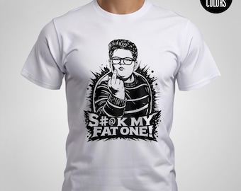 May include: White t-shirt with a black and white graphic of a person wearing glasses and a striped sweater, giving the middle finger. The text "S#@K MY FAT ONE!" is below the graphic. The shirt has a Comfort Colors label.