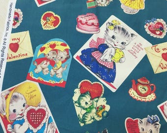 May include: A teal fabric with a repeating pattern of vintage Valentine's Day cards featuring kittens, hearts, and messages like "To my Valentine" and "Hello, It's a Valentine."