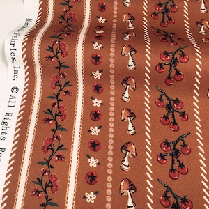 May include: Brown fabric with a repeating pattern of white flowers, red tomatoes, and brown mushrooms. The fabric has a white border with a repeating pattern of small white circles.