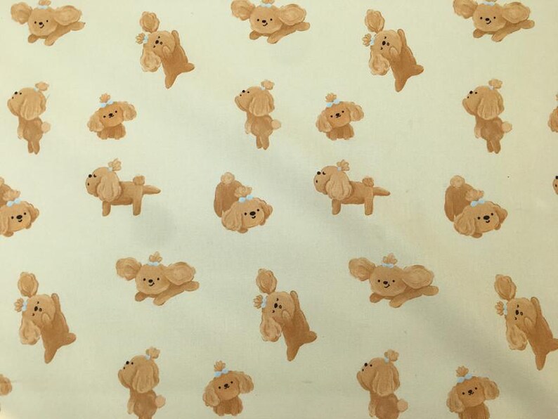 May include: A repeating pattern of cartoon-style brown dogs with white accents and small bows on a light yellow background. The dogs are in various poses, some standing, some sitting, and some jumping.