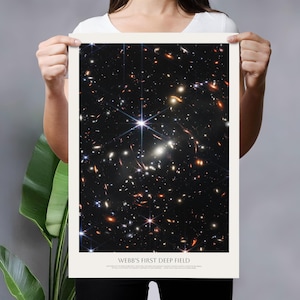 A person is holding up a poster with a picture of a deep field, which is a type of astronomical image.