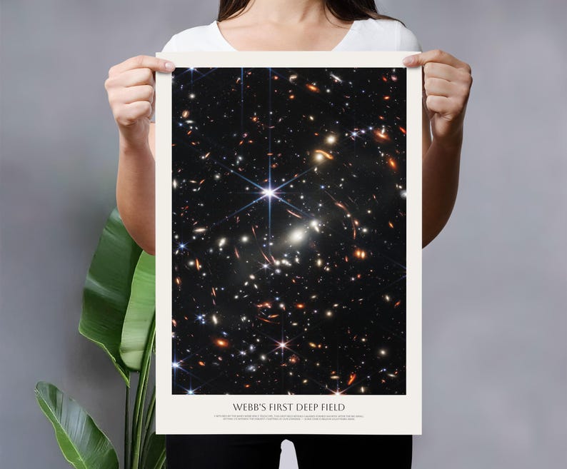 A person is holding up a poster with a picture of a deep field, which is a type of astronomical image.