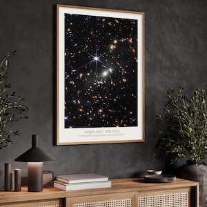 a framed poster of the Webb's First Deep Field, a stunning celestial image of the universe captured by the Hubble Space Telescope.