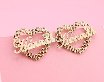 May include: A pair of gold heart-shaped earrings with the names "Hannah" and "Harve" spelled out in cursive.