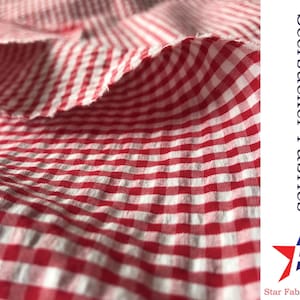 May include: Red and white gingham seersucker fabric. The fabric has a textured, crinkled look and feel. Seersucker Fabrics Star Fabrics Co.