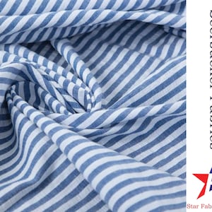 May include: Blue and white striped seersucker fabric. The fabric is folded and has a soft, crinkled texture.