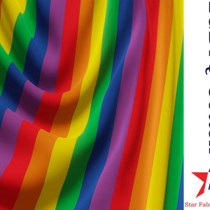 Puede incluir: Tela a rayas de arcoíris con el texto "LGBTQ Cotton" y un logotipo de estrella con el texto "Star Fabrics Co."