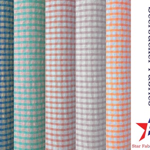 May include: Five different colors of seersucker fabric with a gingham pattern. The colors are blue, green, red, gray, and orange. The fabric is displayed on a white background with the text "Seersucker Fabrics" and a star logo.