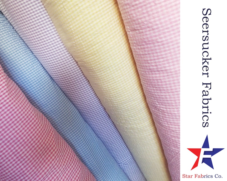 May include: Four rolls of seersucker fabric in pink, light blue, lavender, and yellow. The fabric has a small gingham pattern. The text "Seersucker Fabrics" and "Star Fabrics Co." is visible in the image.
