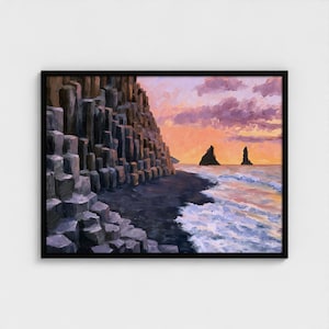 May include: A framed oil painting depicting a coastal landscape with dark basalt columns on the left, a black sand beach, and ocean waves washing ashore. In the distance, two jagged rock formations rise from the sea under a sunset sky.