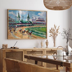 Puede incluir: Pintura enmarcada que representa una carrera de caballos. La obra presenta un hip&oacute;dromo con caballos y jinetes, gradas y un campo verde. La paleta de colores incluye tonos de marr&oacute;n, verde, azul y blanco, creando una escena vibrante.
