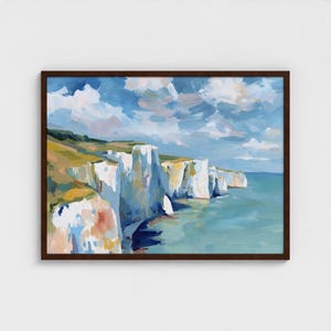 May include: A framed landscape painting depicting white cliffs and a turquoise sea under a blue sky with clouds. The artwork, in a dark brown frame, features brushstrokes of green, yellow, and white, capturing a coastal scene.