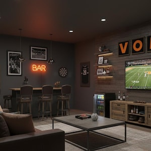 May include: A sports-themed entertainment room with a bar, TV, and seating. The room features framed jerseys, a neon "BAR" sign, and "VOLS" signage. A TV displays a football game, and a mini-fridge is visible.