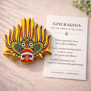 以下が含まれることがあります： スリランカの民間伝承に登場する火の悪魔、Gini Rakshaの黄色、赤、黒のマスク。口を開けたマスクには、その象徴性と治癒儀式での使用法を説明するカードが添えられています。