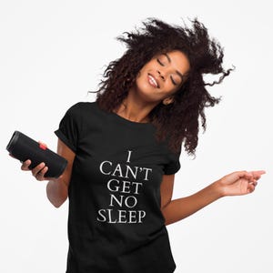 Black unisex tee with large white text saying “I Can’t Get No Sleep” on a plain background, insomnia quote tee, music‑inspired slogan top.