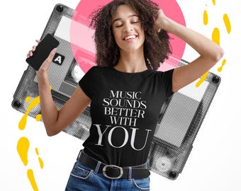 May include: A black short-sleeved t-shirt featuring the white text "MUSIC SOUNDS BETTER WITH YOU" printed on the front. The shirt is paired with blue denim jeans and a black belt, set against a graphic background of a cassette tape.