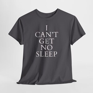 Black unisex tee with large white text saying “I Can’t Get No Sleep” on a plain background, insomnia quote tee, music‑inspired slogan top.