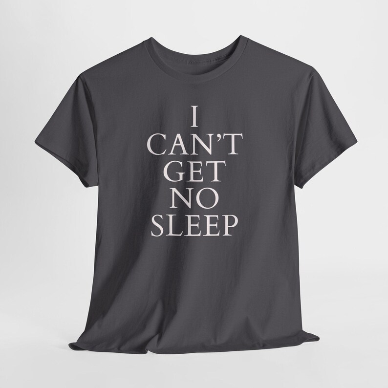 Black unisex tee with large white text saying “I Can’t Get No Sleep” on a plain background, insomnia quote tee, music‑inspired slogan top.