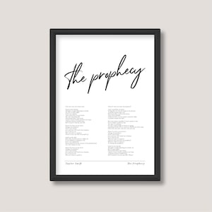 May include: Black and white printable wall art featuring the lyrics to Taylor Swift's song "The Prophecy". The title "The Prophecy" is written in cursive at the top of the page. The lyrics are printed in a simple font.