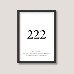 May include: Black and white framed print with the number 222 and the text "ANGEL NUMBERS" and "ALIGNMENT". The text below the number reads "trust in the balance of life's harmony and peace are guiding you towards your highest purpose".