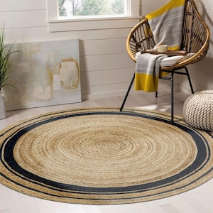 May include: A round jute rug with a dark blue border. The rug has a natural, woven texture and is placed on a light-colored wooden floor. The rug is approximately 60 inches in diameter, perfect for a living room or bedroom.