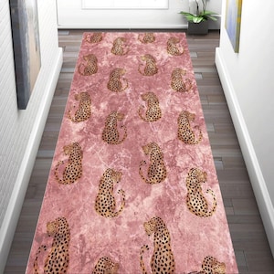 Könnte beinhalten: Ein rosa Läufer mit Marmoroptik und einem sich wiederholenden Muster aus stilisierten Leopardenfiguren in Braun- und Schwarztönen. Der Teppich ist rechteckig und für einen Flur oder Eingangsbereich geeignet.