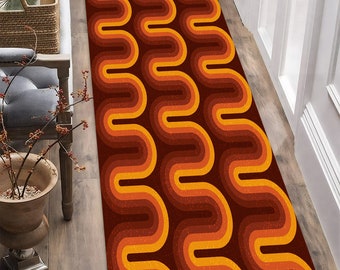May include: A long, narrow rug with a retro-inspired design. The rug features a repeating pattern of wavy lines in shades of orange, brown, and yellow.