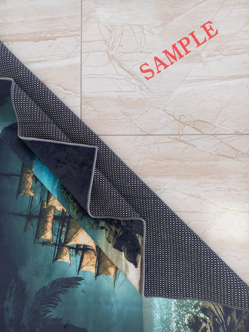 May include: A rolled-up area rug featuring a detailed illustration of a tall ship sailing on a dark, misty sea. The rug's design includes a palm tree and rocky cliffs. The word "SAMPLE" is printed in red on the background.