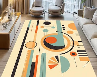 May include: A beige area rug with an abstract geometric design. The rug features orange, black, teal, and beige shapes, including circles, lines, and a semi-circle. The rug is placed in a living room setting.