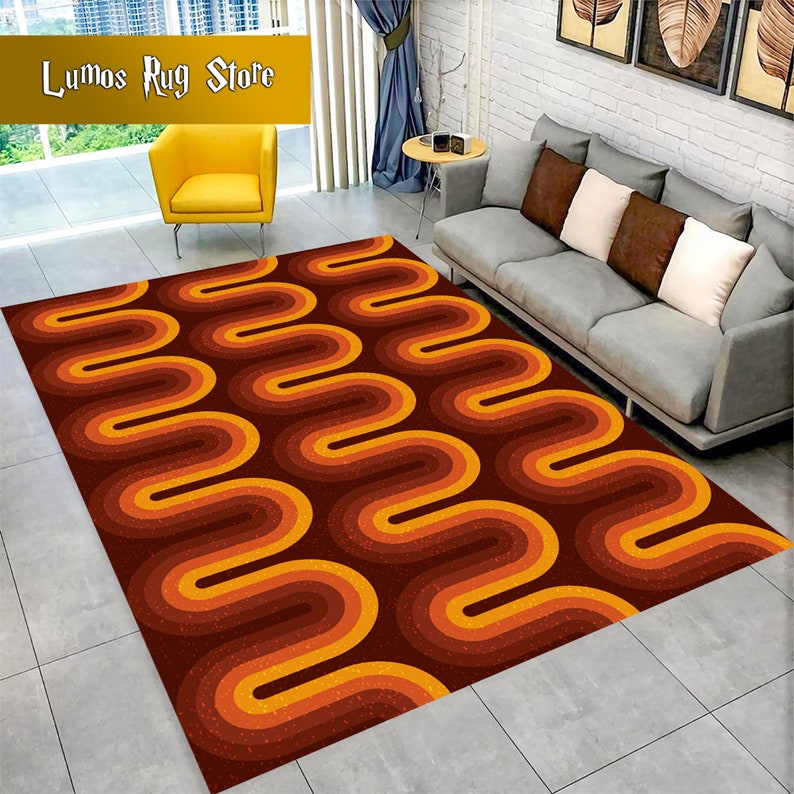 May include: A brown and orange geometric patterned rug with a wavy design. The rug is in a living room setting with a couch and a chair.