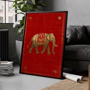 May include: Framed art print featuring a golden elephant with ornate detailing on a vibrant red background. The elephant is adorned with a decorative blanket. The artwork is framed in a black border, adding a touch of elegance to the piece.