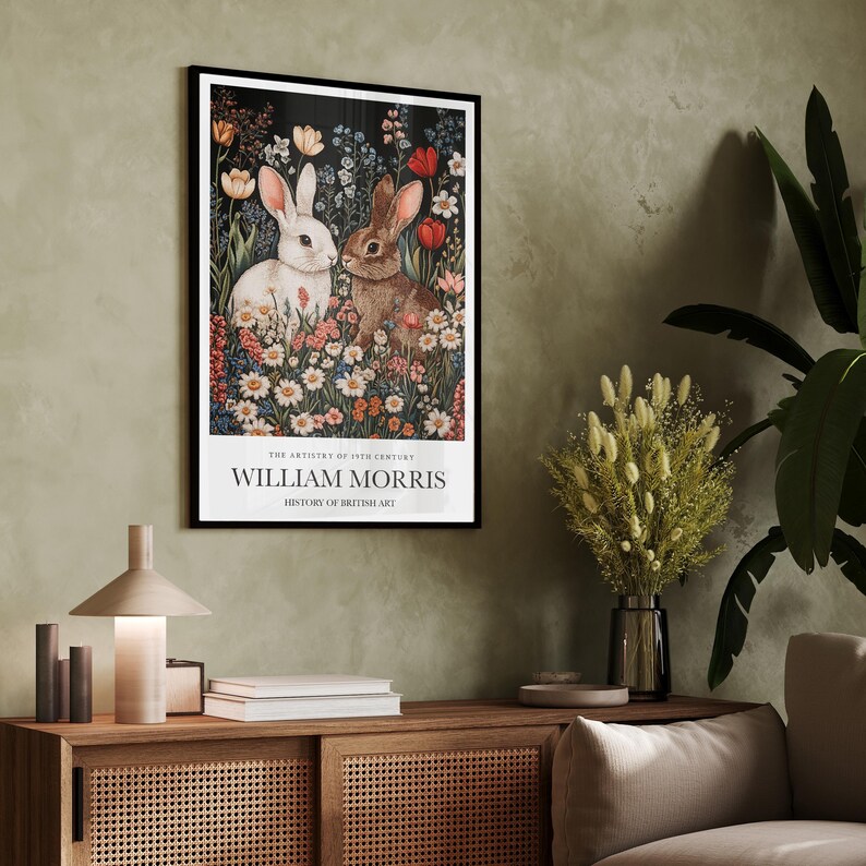 May include: A framed print of a vintage illustration featuring two white rabbits in a field of colourful flowers. The text on the print reads "The Artistry of 19th Century William Morris History of British Art".