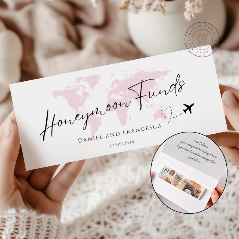 K&ouml;nnte beinhalten: Eine rechteckige wei&szlig;e Karte mit einer hellrosa Weltkarte, dem schwarzen kursiven Text Honeymoon Funds sowie den Namen Daniel und Francesca und dem Datum 27/09/2026. Ein kleines schwarzes Flugzeugsymbol folgt einer gepunkteten Herzlinie.