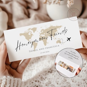 K&ouml;nnte beinhalten: Eine rechteckige wei&szlig;e Karte mit einer beigen Weltkarte, dem Text "Honeymoon Funds", "DANIEL AND FRANCESCA" und "27/09/2026". Ein kleines Flugzeugsymbol folgt einer gepunkteten Herzlinie. Ein Inset zeigt die offene Karte mit einem Zehn-Pfund-Schein.