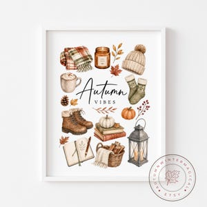 May include: A watercolour illustration featuring autumn-themed objects. It includes a plaid scarf, candle, hat, socks, pumpkin, boots, books, journal, basket, lantern, and the text "Autumn Vibes". The colour scheme uses warm browns, oranges, and creams.