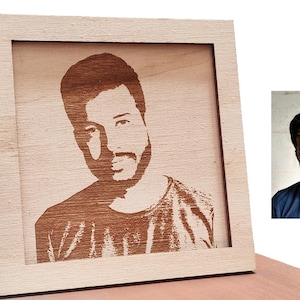 Könnte beinhalten: Ein Holzrahmen mit einem lasergravierten Porträt einer Person. Das Porträt ist in Brauntönen gehalten und zeigt das Gesicht und die Schultern der Person.