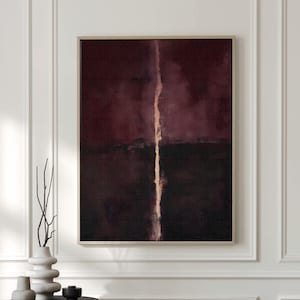 May include: Abstract canvas art with a deep burgundy and black color palette, featuring a vertical, light-colored streak. The artwork is framed and displayed above a sofa. Text at the bottom reads "CURIOSITY ES ART | HIGH QUALITY CANVAS."