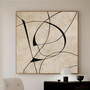 Puede incluir: Obra de arte abstracta con líneas negras sobre fondo beige, enmarcada en madera clara. La obra cuelga sobre un mueble negro con una lámpara blanca y un cuenco negro. El texto "CURIOSITY ES ART | HIGH QUALITY CANVAS" es visible.