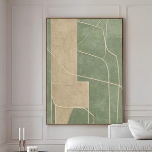 Puede incluir: Un gran póster de arte abstracto enmarcado, con formas geométricas beige y verdes y líneas blancas. Una mesa de centro redonda negra y un sofá blanco están en primer plano. El texto "CURIOSITY ES ART | FINE ARTS POSTER" está en la parte inferior.