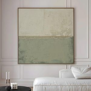 May include: Large abstract canvas art with a neutral color palette. The artwork features a textured surface with a light beige upper section and a muted green lower section, framed in a brown wooden frame. The text "CURIOSITY ES ART | HIGH QUALITY CANVAS" is at the bottom.