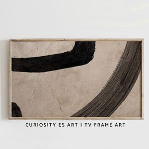 Puede incluir: Impresión artística abstracta en un marco de madera. La obra presenta audaces pinceladas negras sobre un fondo beige. El texto "CURIOSITY ES ART I TV FRAME ART" está impreso en la parte inferior del marco.