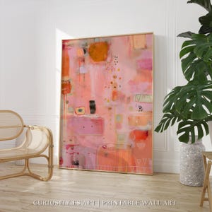 Puede incluir: Gran impresión artística abstracta enmarcada. La obra presenta una mezcla de tonos rosa, naranja y melocotón con formas geométricas y pinceladas. El texto "CURIOSITY ES ART | PRINTABLE WALL ART" está en la parte inferior.