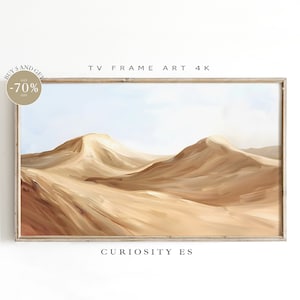 Puede incluir: Una impresión de arte digital de un paisaje desértico con colinas onduladas en tonos marrones y beige. La impresión está enmarcada en un marco de madera claro. El texto "TV FRAME ART 4K" y "CURIOSITY ES" son visibles debajo de la imagen.
