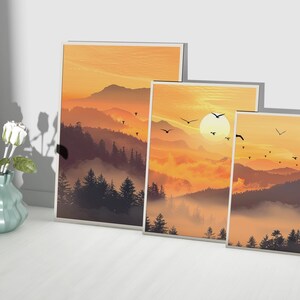 Puede incluir: Tres impresiones art&iacute;sticas enmarcadas que representan un paisaje monta&ntilde;oso al atardecer. La obra de arte presenta una c&aacute;lida paleta de colores naranjas y marrones, con siluetas de &aacute;rboles y p&aacute;jaros volando. Un jarr&oacute;n con rosas blancas est&aacute; cerca.